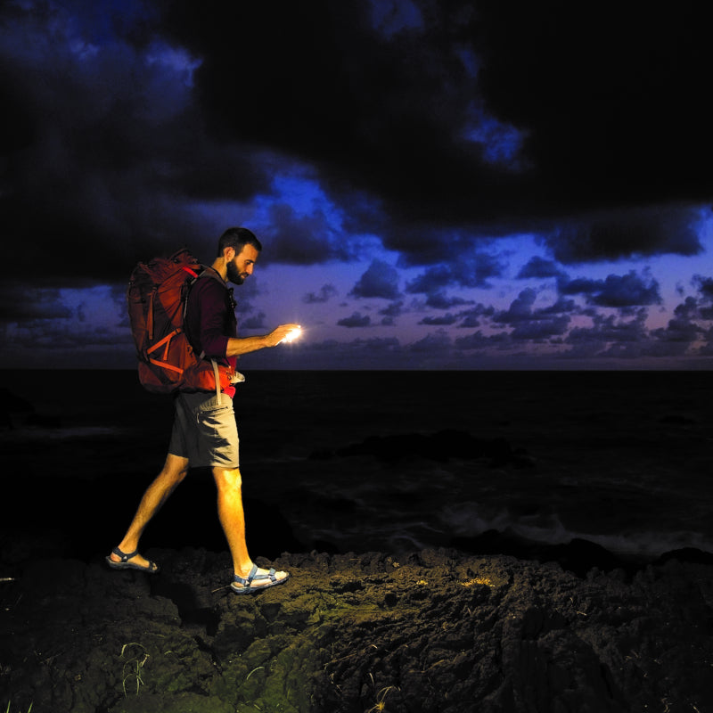 A man seen wayfinding in the dark using a BioLite SunLight 100 to help light the way.